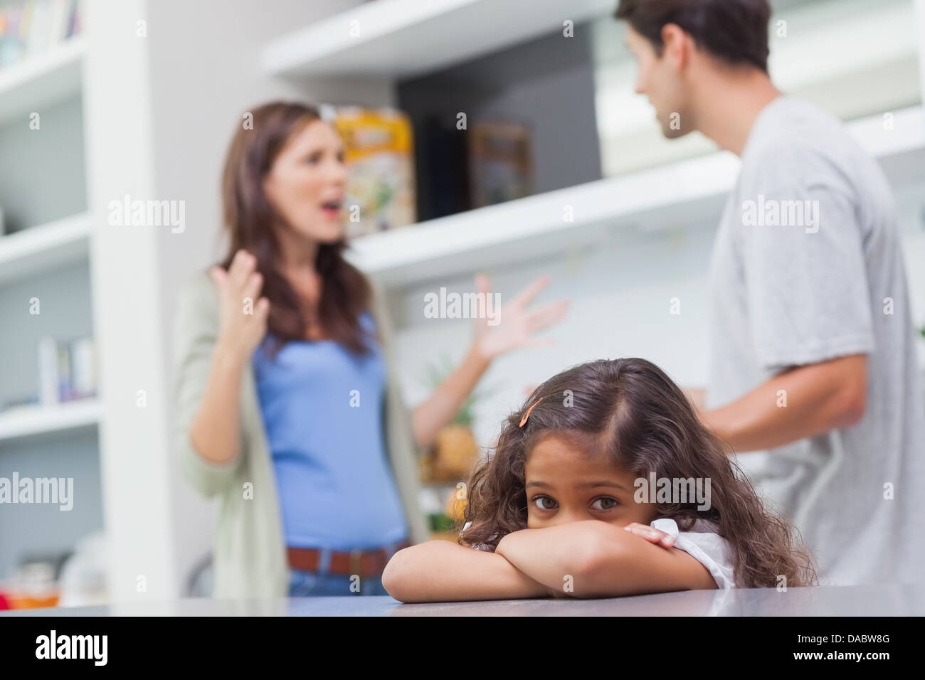 Sad girl listening to her parents arguing Stock Photo