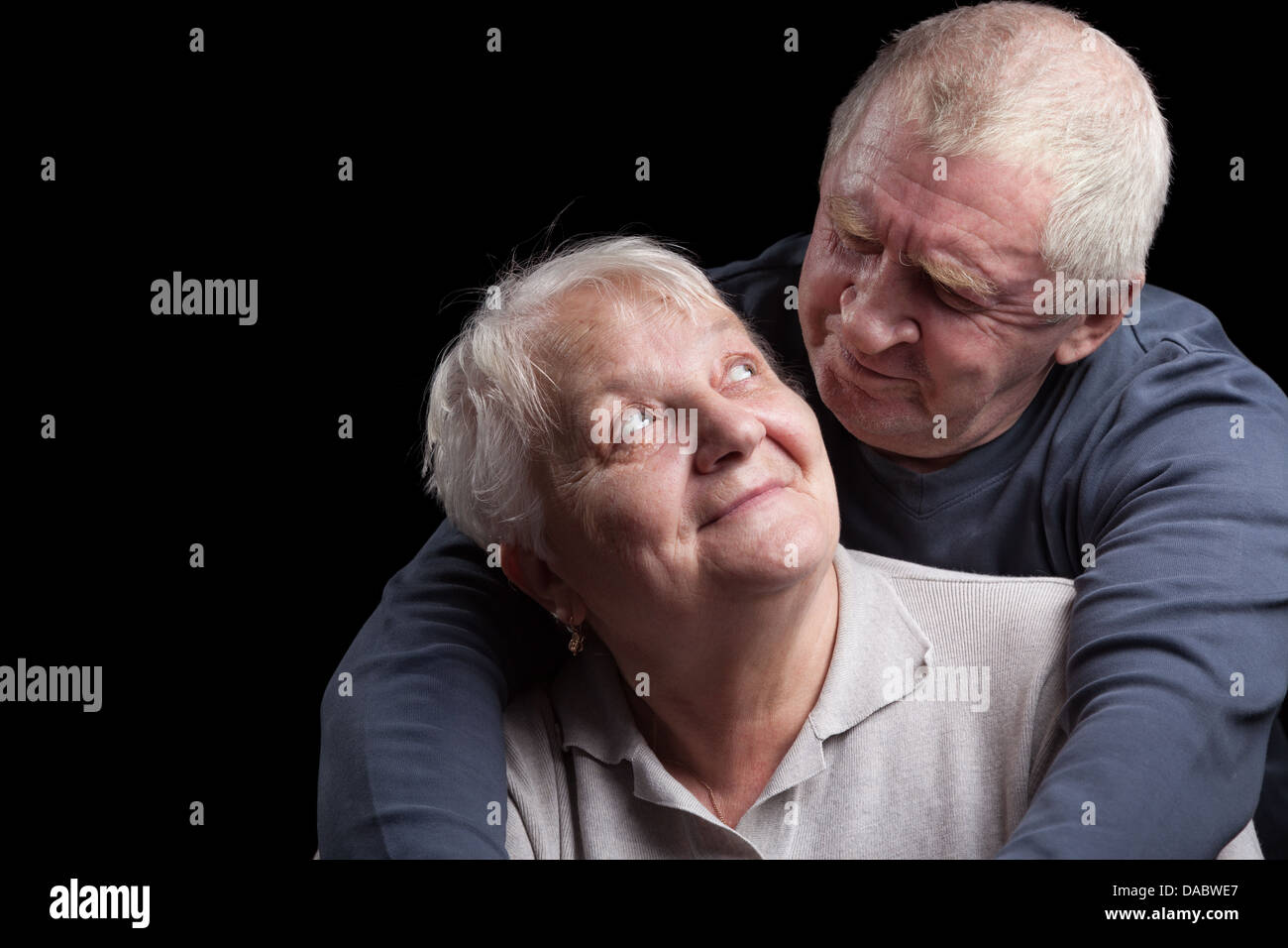 A loving, handsome senior couple on a black background. Stock Photo