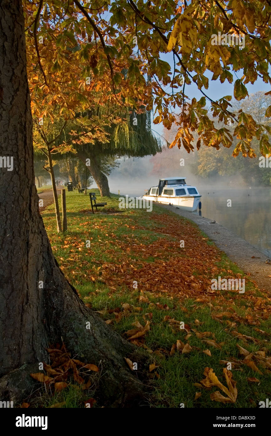 Stratford upon Avon, River Avon, Warwickshire and a white motor cruiser moored on a misty autumn morning. Stock Photo