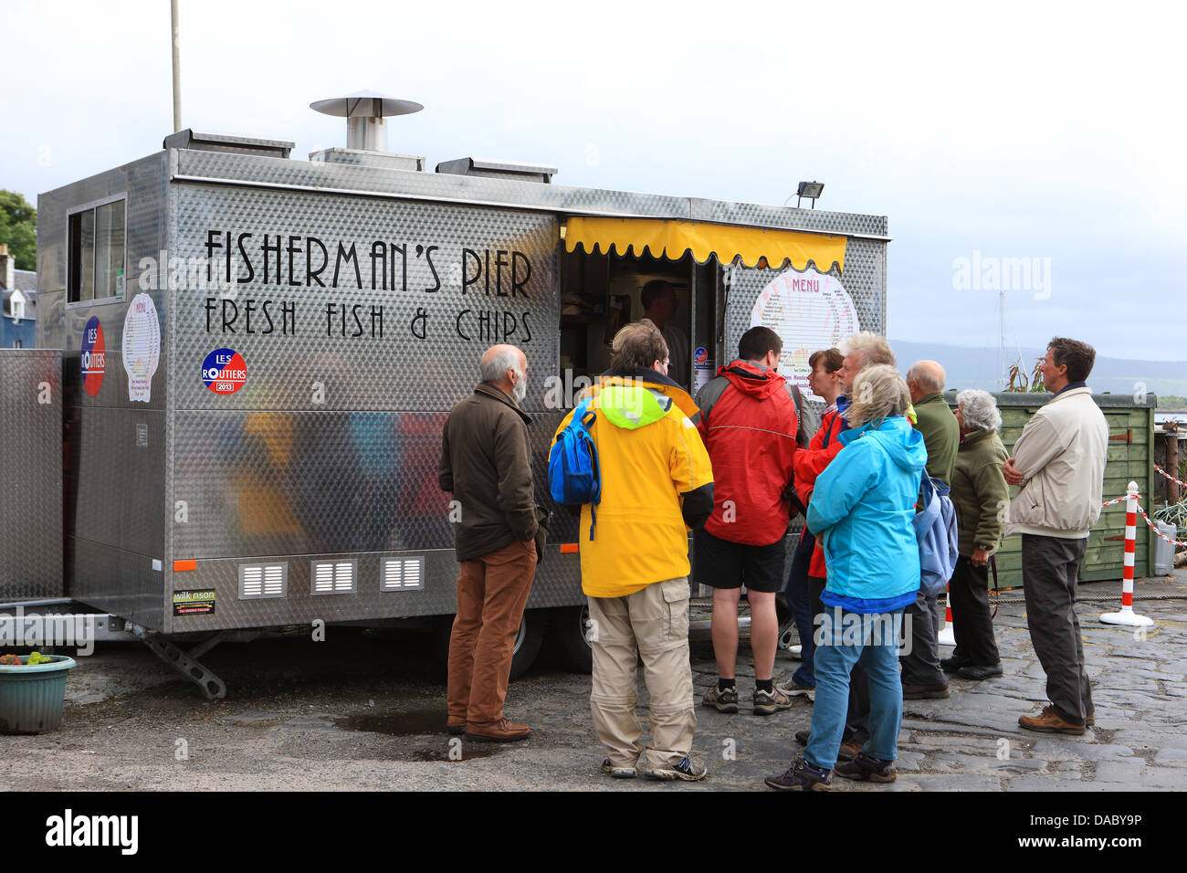 Tourists buying fish & chips from the award winning 'Les Routiers' Fisherman's Pier van in Tobermory Isle of Mull Stock Photo