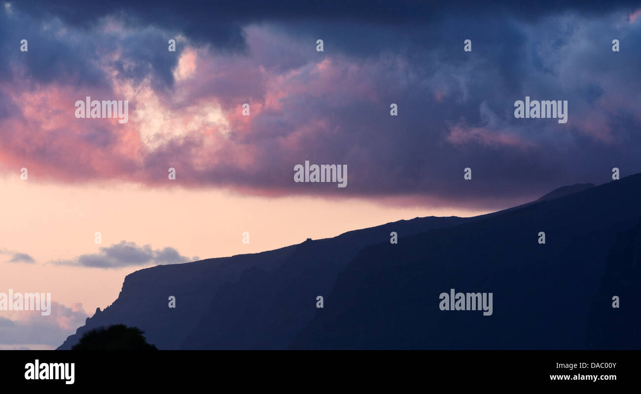 Los Gigantes cliffs seen from Playa San Juan with storm clouds at sunset, Tenerife, Canary Islands, Spain, Stock Photo