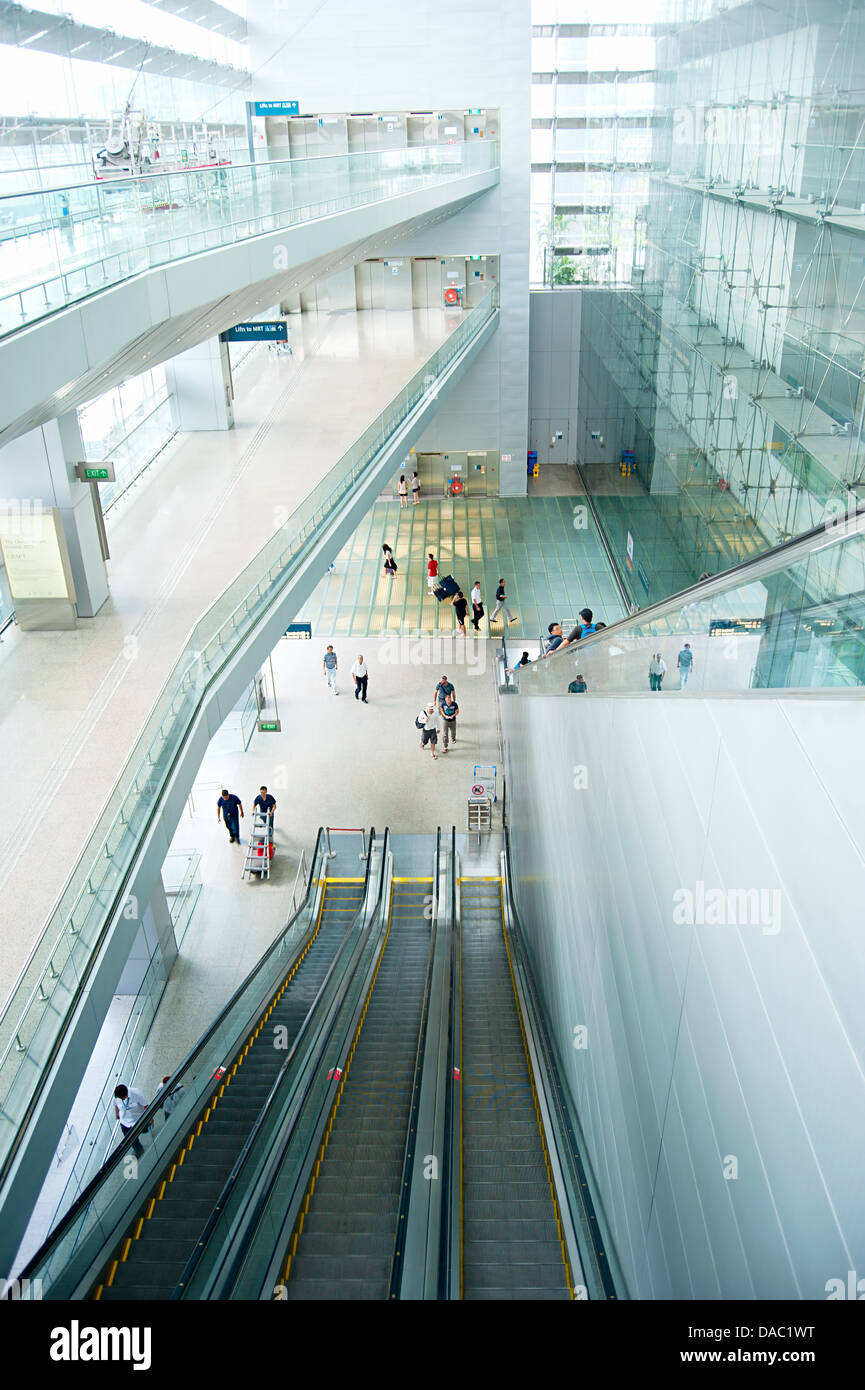 People at escalators at Changi International Airport. Stock Photo