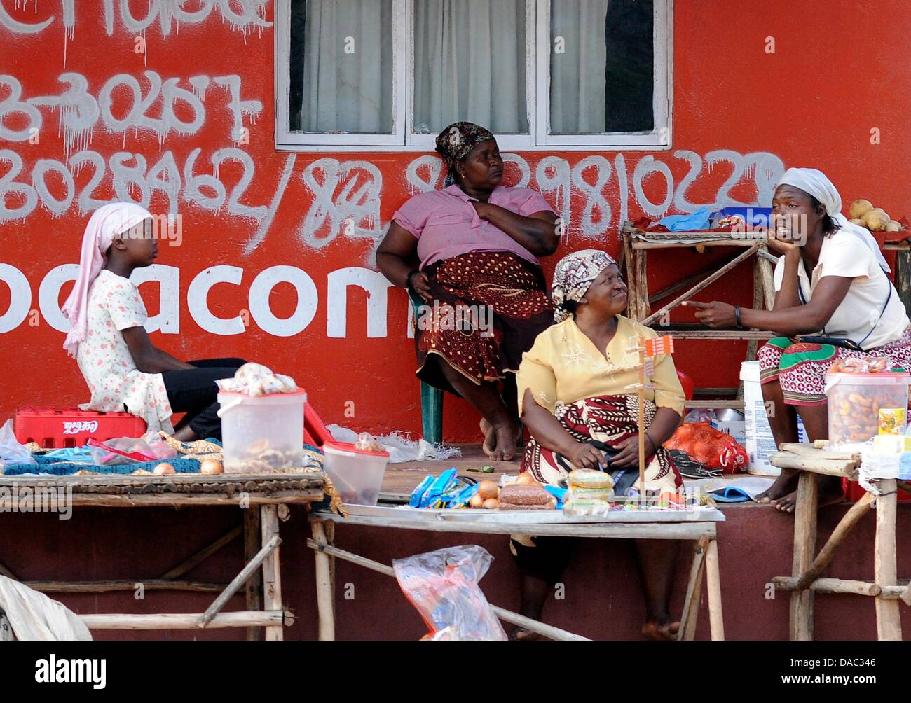 Women sell various goods on the side of a road in Xai-Xai, Mozambique