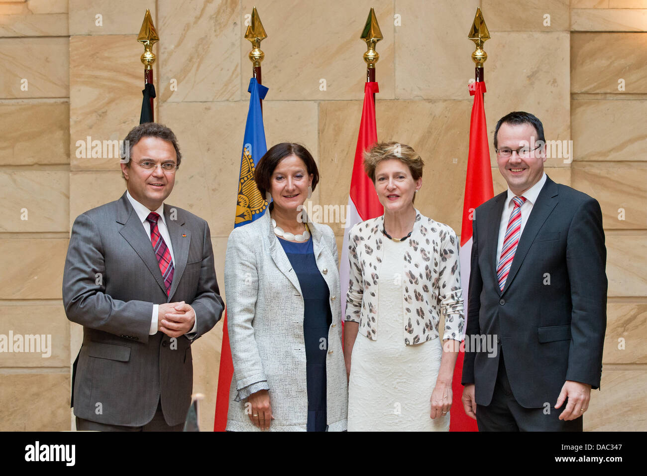 German interior minister Hans-Peter Friedrich (CSU, L-R), Austrian interior minister Johanna Mikl-Leitner (OeVP), Simonetta Sommaruga (SP), head of the Swiss justice and police department (EJPD), and Thomas Zwiefelhofer (VU), minister for interior affairs, justice, and economy of Liechtenstein, stand in front of the national flags at a meeting of interior ministers from German speaking countries in Nuremberg, Germany, 10 July 2013. The ministers want to talk about human trafficking, immigration, and integration as well as the situation of the Syrian refugees at the meeting. Stock Photo