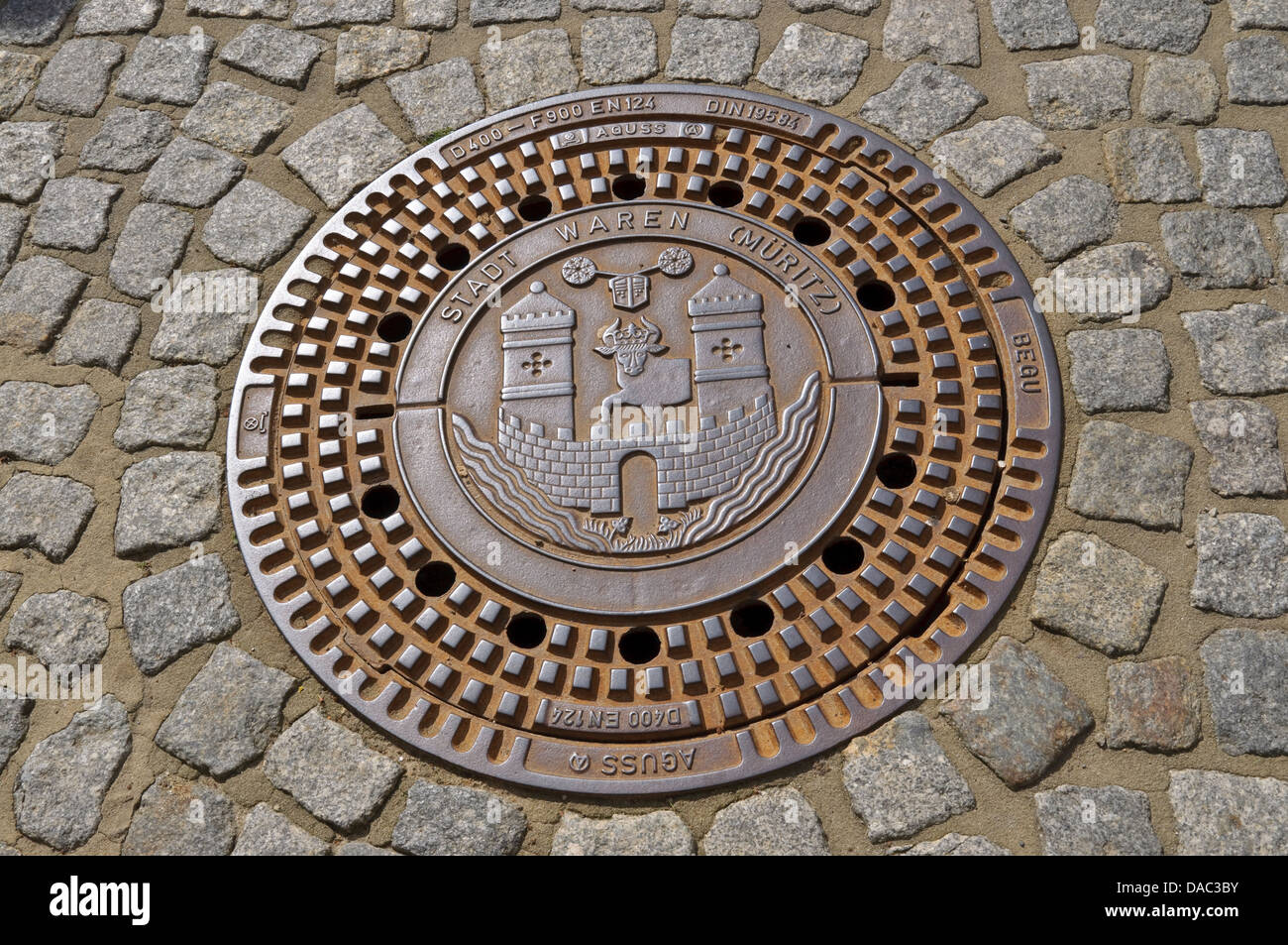Decorative man hole cover with Waren coat of arms, Germany. Stock Photo