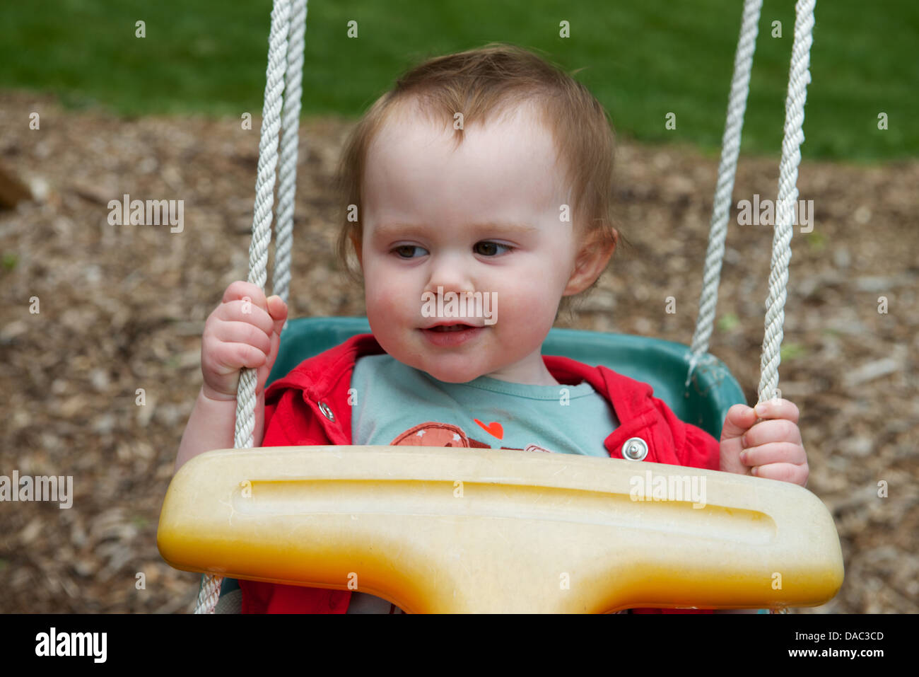 Infant Toddler Girl on Playground Swing Stock Photo