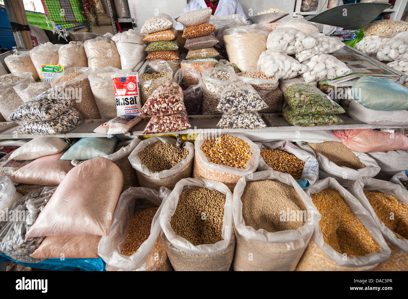 Bags of grain beans corn produce dry goods stall shop vendor in local market Cusco, Peru. Stock Photo