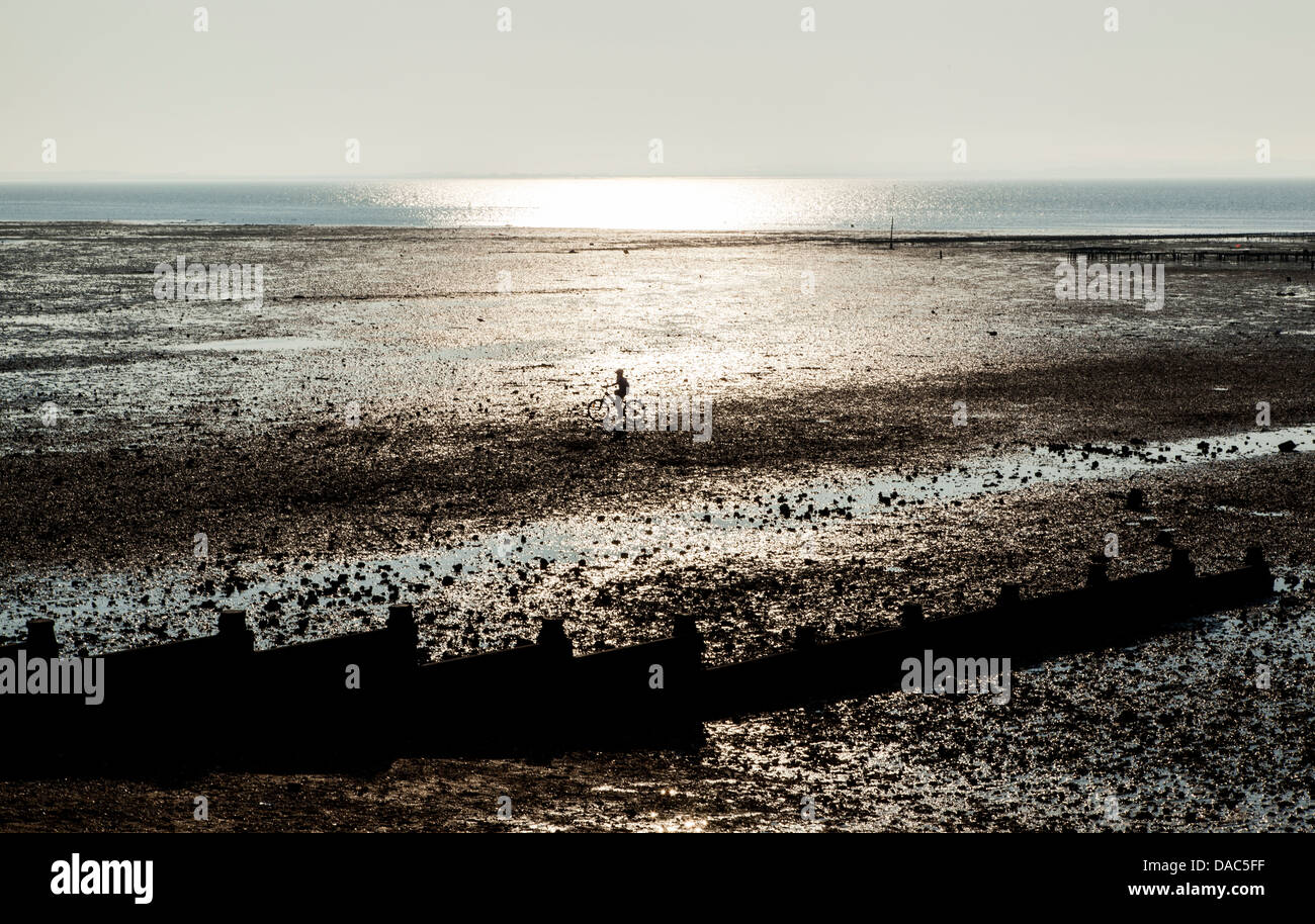 sunset at Whitstable beach, England, cyclist Stock Photo