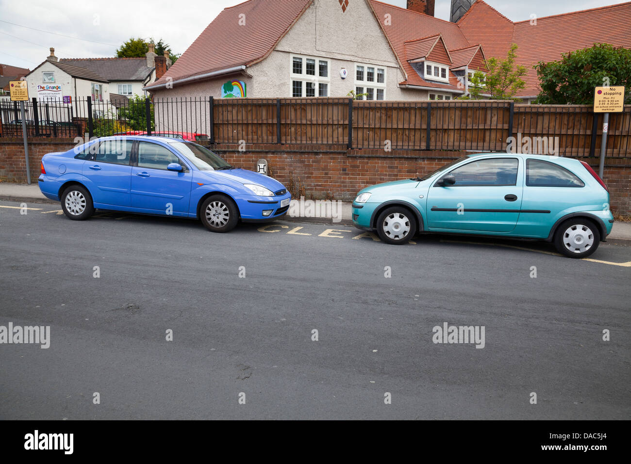 cars parked outside school on keep clear sign in Alfreton, Derbyshire, England Stock Photo