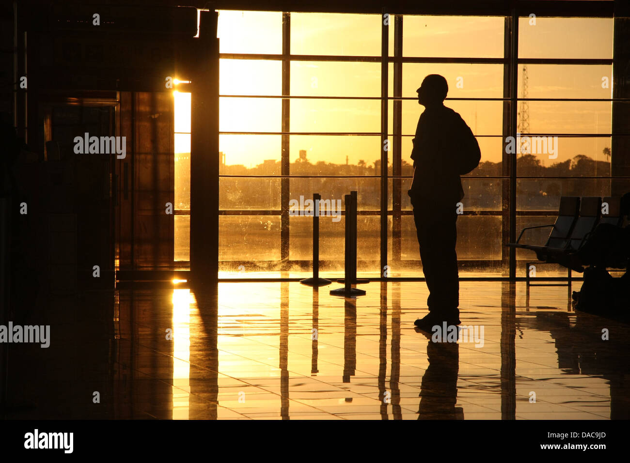Man in profile waiting at an airport with a golden sunset Stock Photo