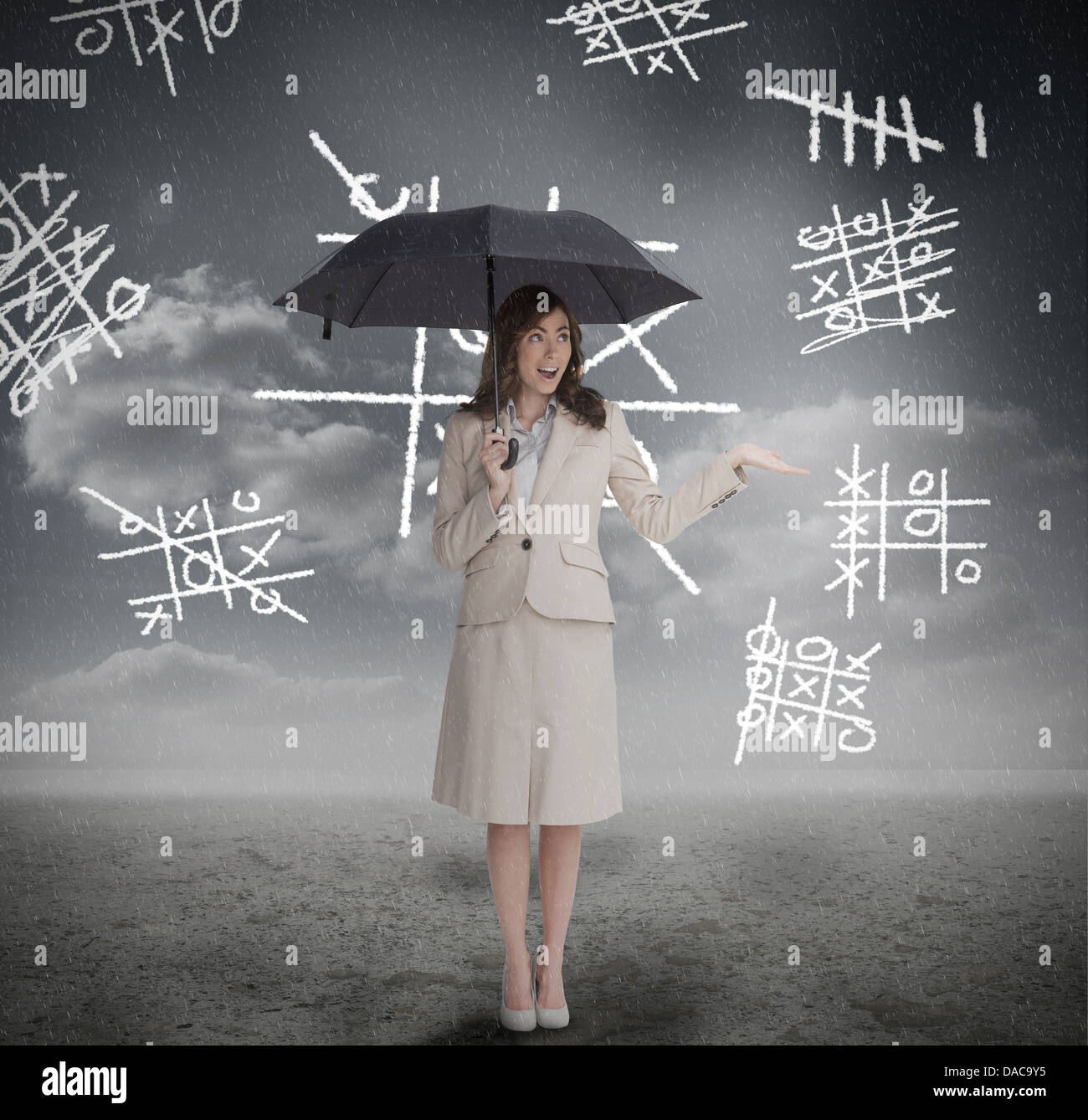 Businesswoman with noughts and crosses holding umbrella Stock Photo