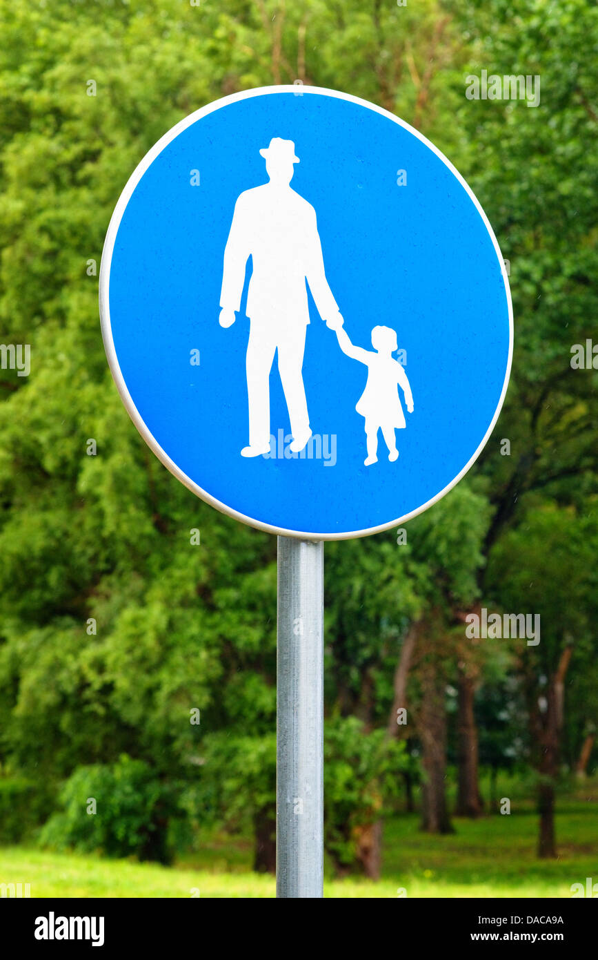 Pedestrian walkway road sign. Illustration of old man holding little girl by the hand. Stock Photo