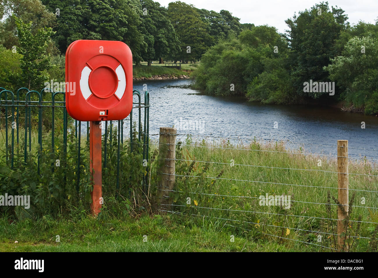 red life preserver in a riverside setting at local park Stock Photo