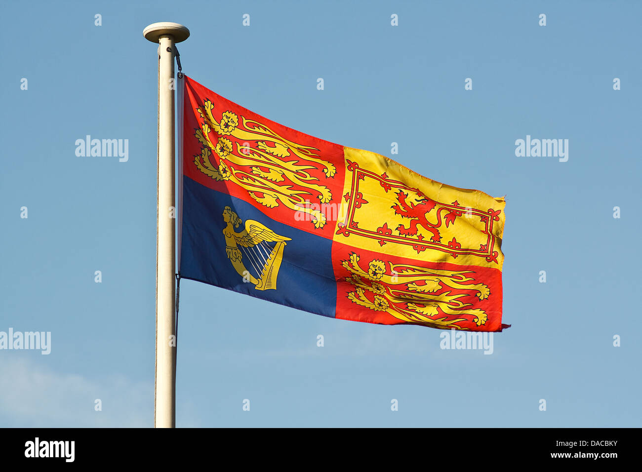 The Traditional Royal Standard Flag ripples in the wind on flagpole Stock Photo