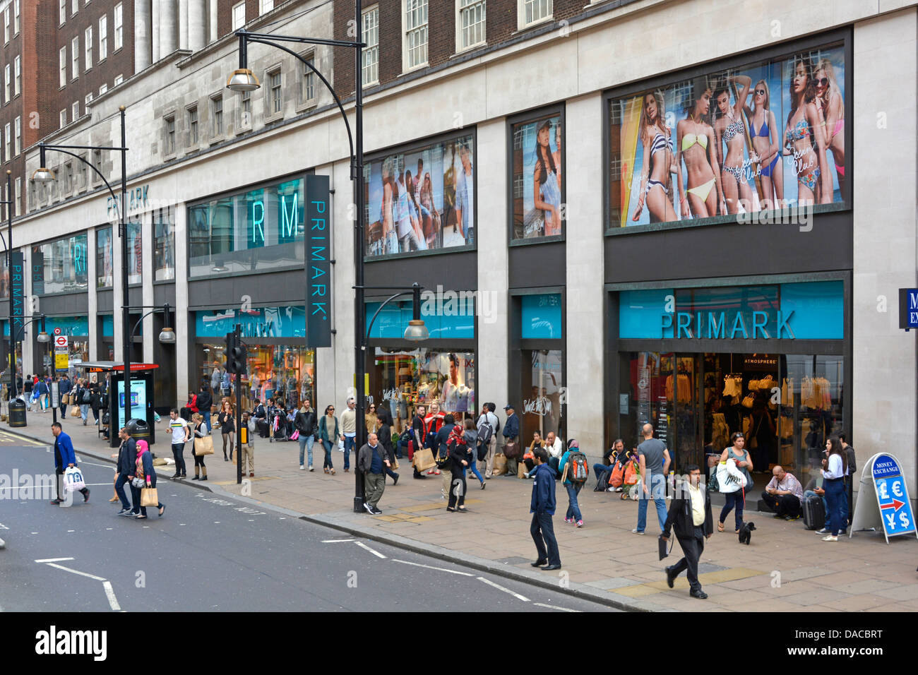 Busy pavement with shoppers outside Primark fast fashion clothing retail business shop front & store windows Oxford Street West End London England UK Stock Photo