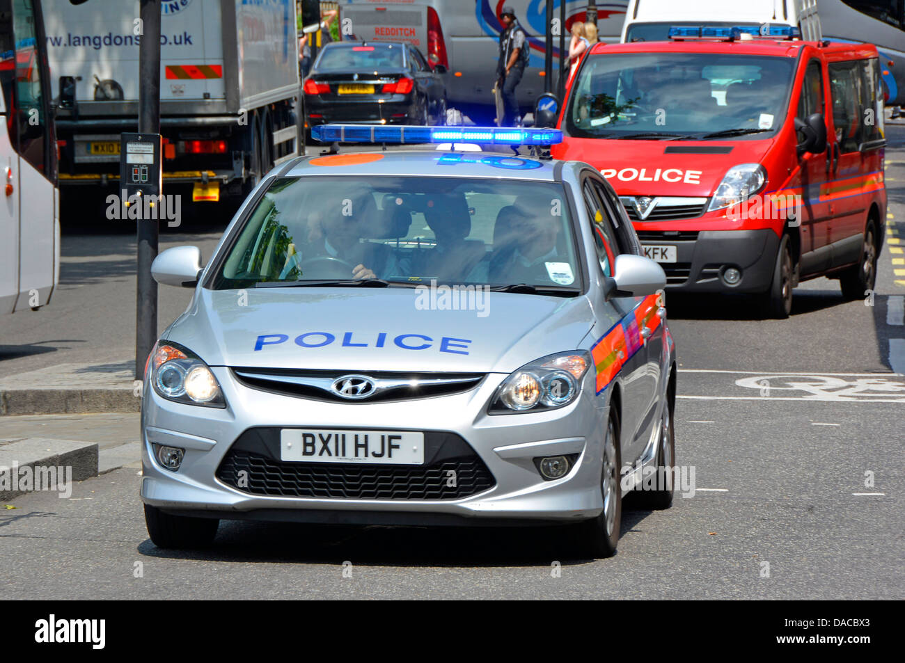 Blue lights on Metropolitan police car followed by police red Protection Command vehicle Central