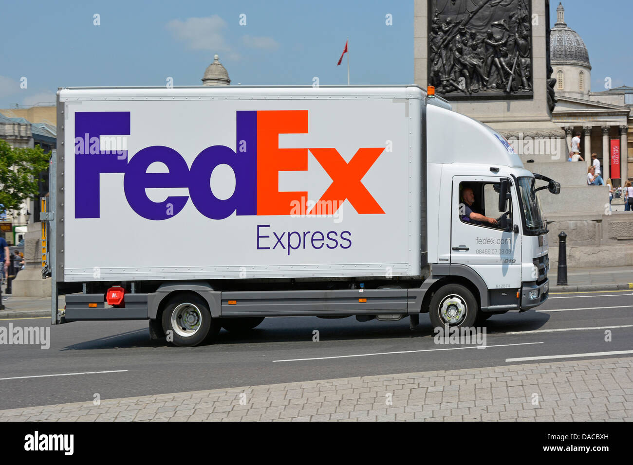 FedEx Express white delivery lorry truck side view of business logo branding and driver in Trafalgar Square  London England UK Stock Photo