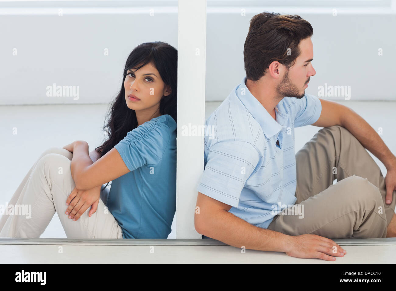 Sitting couple are separated by wall Stock Photo