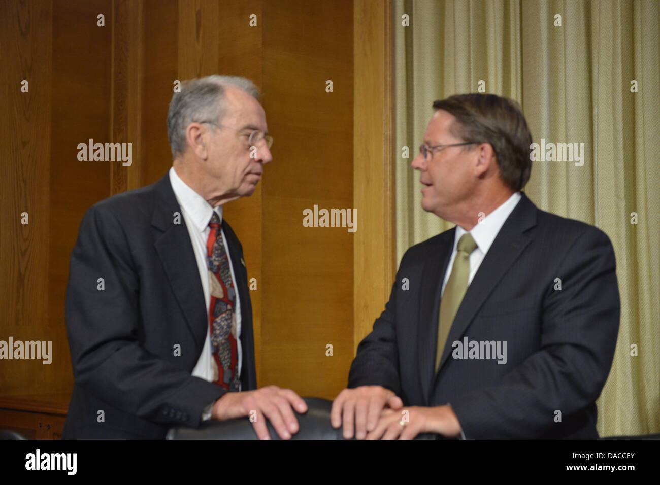 Washington, DC, USA. 10th July, 2013. Sen. CHUCK GRASSLEY, D-IA, left, speaks with LARRY POPE, president and CEO of pork producer Smithfield Foods, Inc. before a heairng of the U.S. Senate Agriculture Committee on the proposed takeover of Smithfield by Shuanghui International, a Chinese company. © Jay Mallin/ZUMAPRESS.com/Alamy Live News Stock Photo
