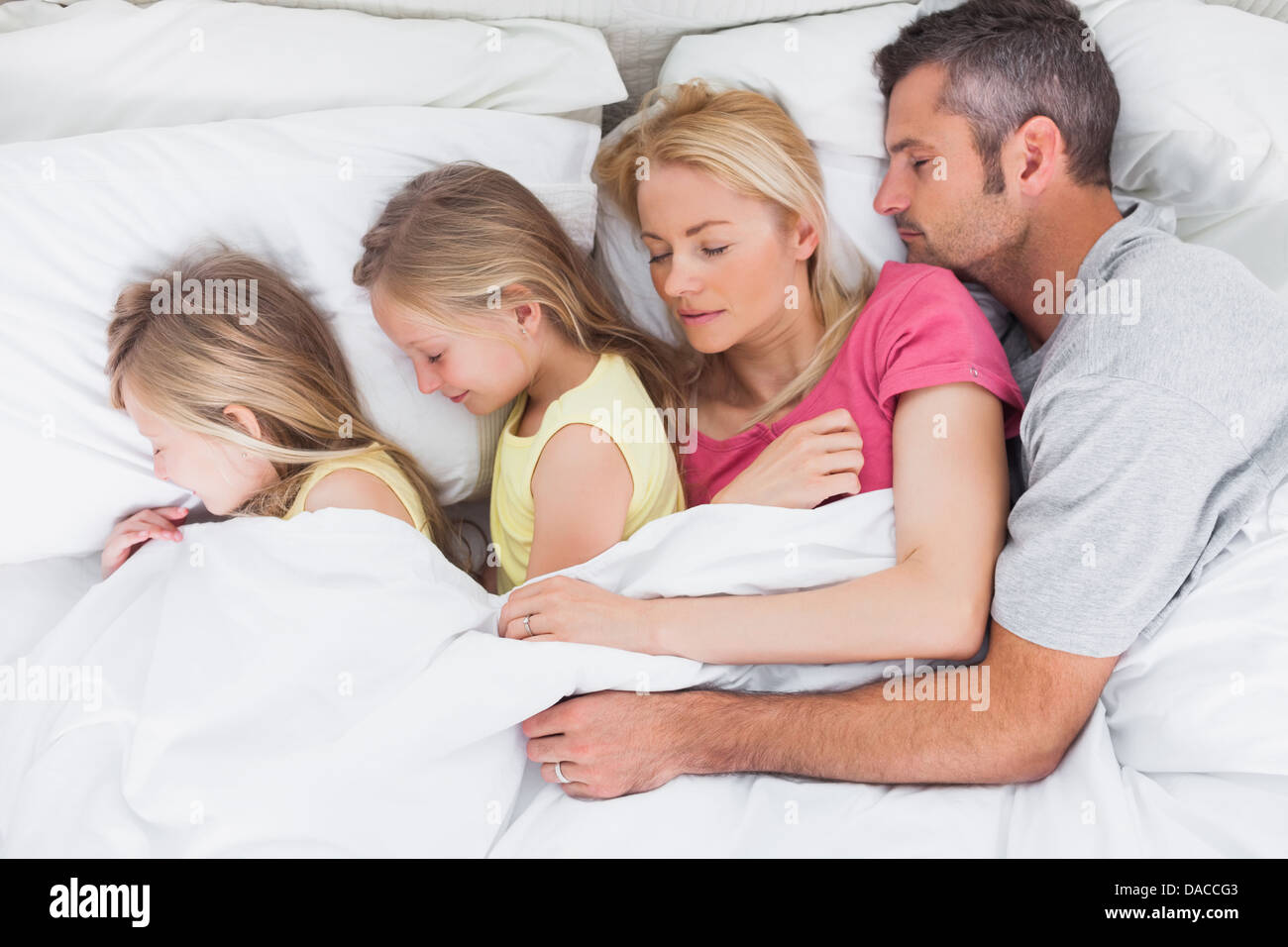 Parents sleeping in bed with their twins Stock Photo Alamy