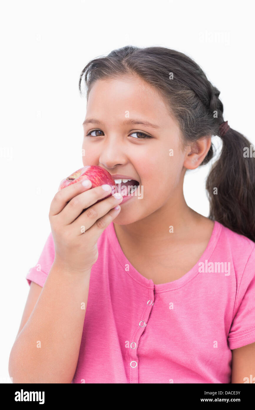 Smiling little girl eating apple Stock Photo