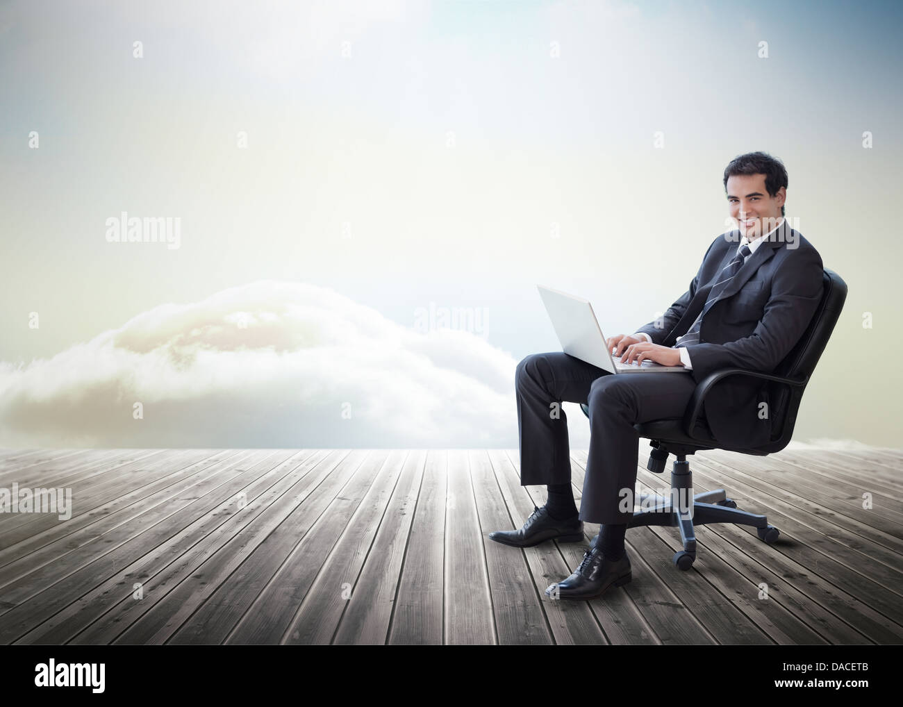 Handsome businessman sitting on a swivel chair and using his laptop ...