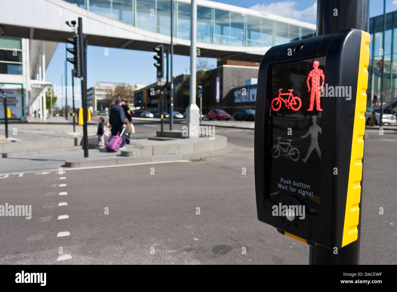 Pedestrian crossing control box displays red man icon after family have safely crossed road. Slough, Berkshire, England. Stock Photo