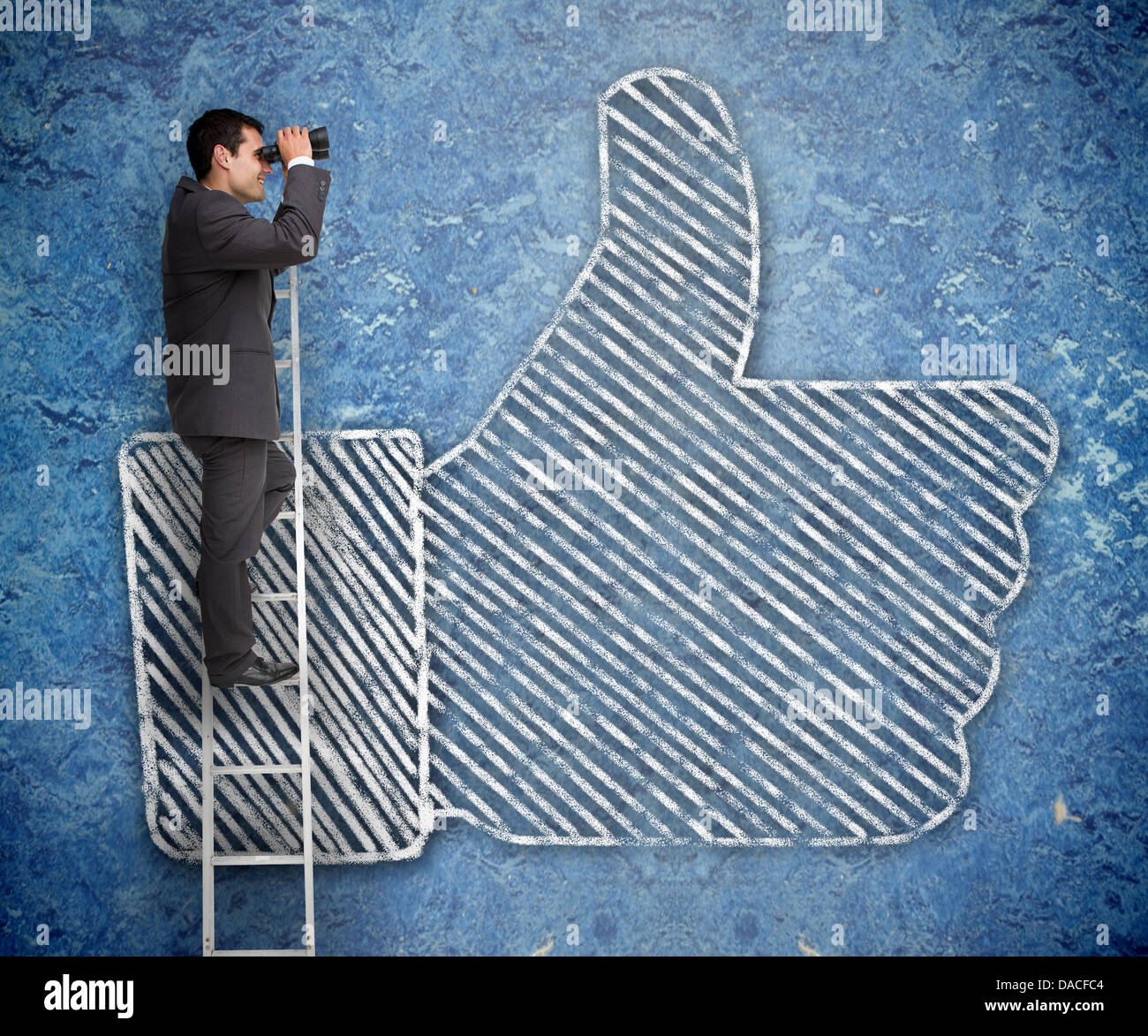 Businessman on a ladder with a thumb up behind Stock Photo