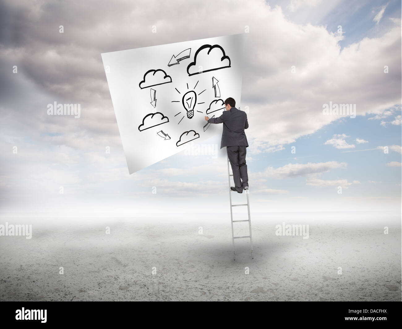 Businessman standing on a ladder drawing a process Stock Photo
