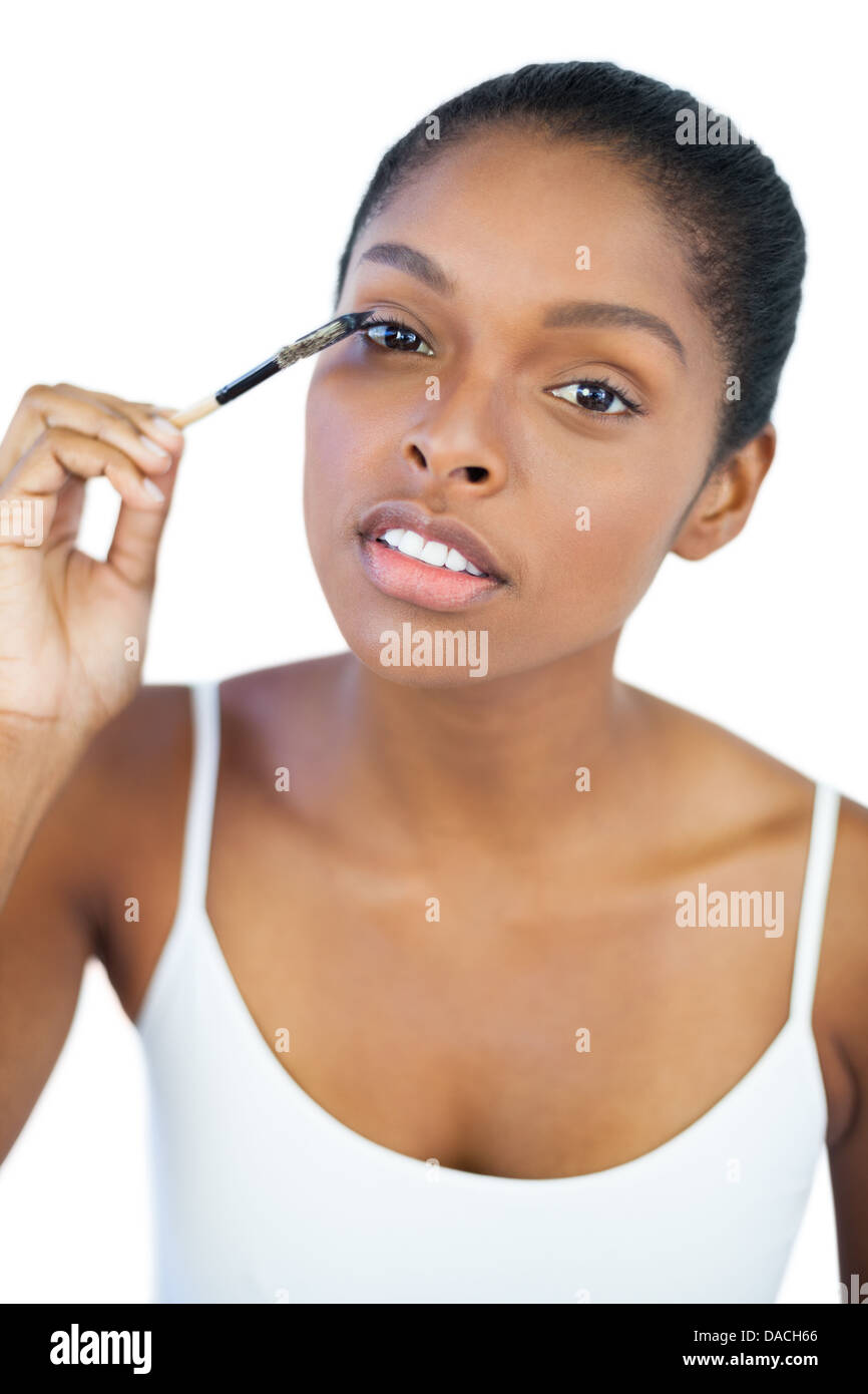 Dark haired woman putting on mascara Stock Photo