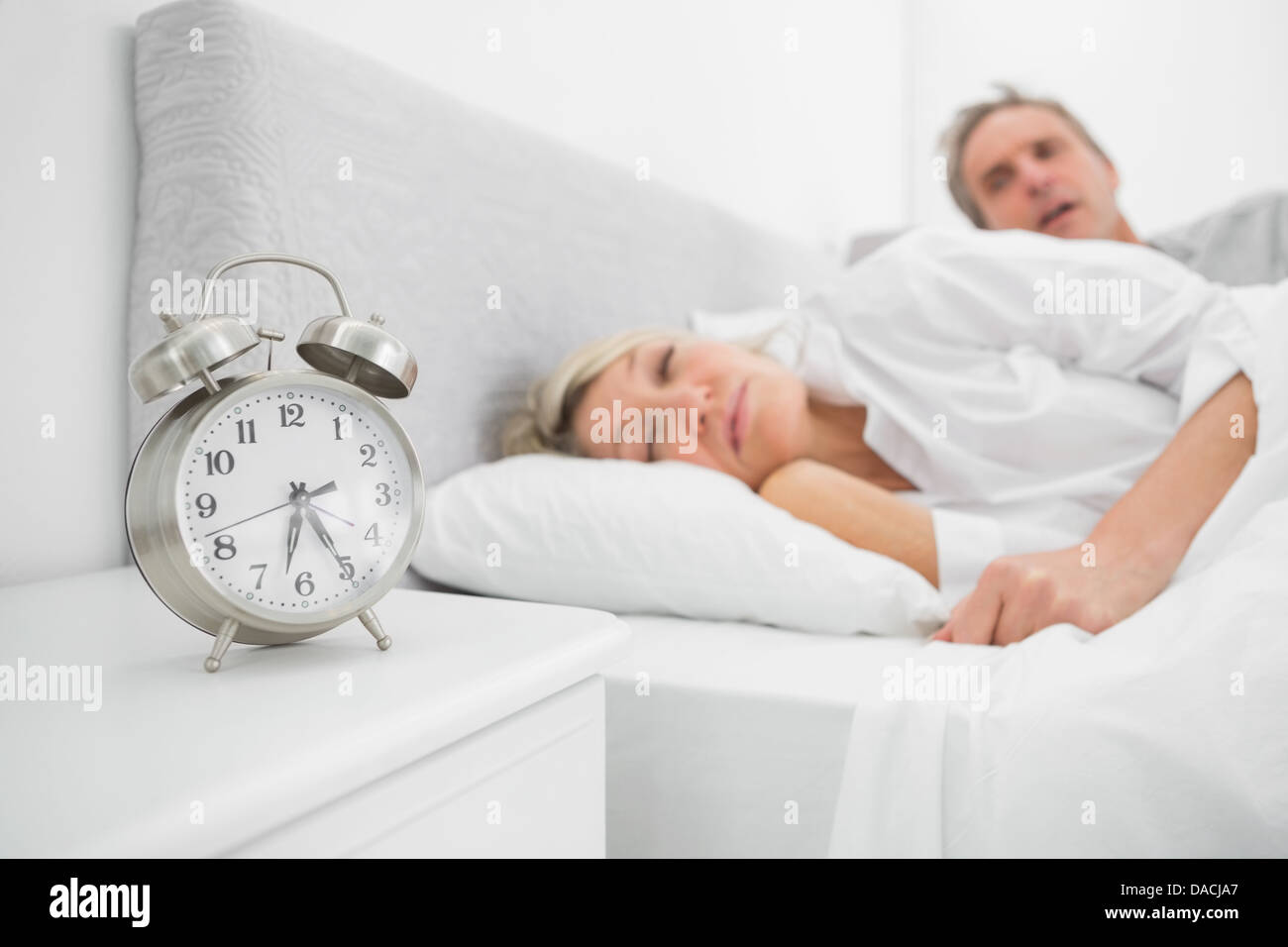 Man looking at ringing alarm clock Stock Photo