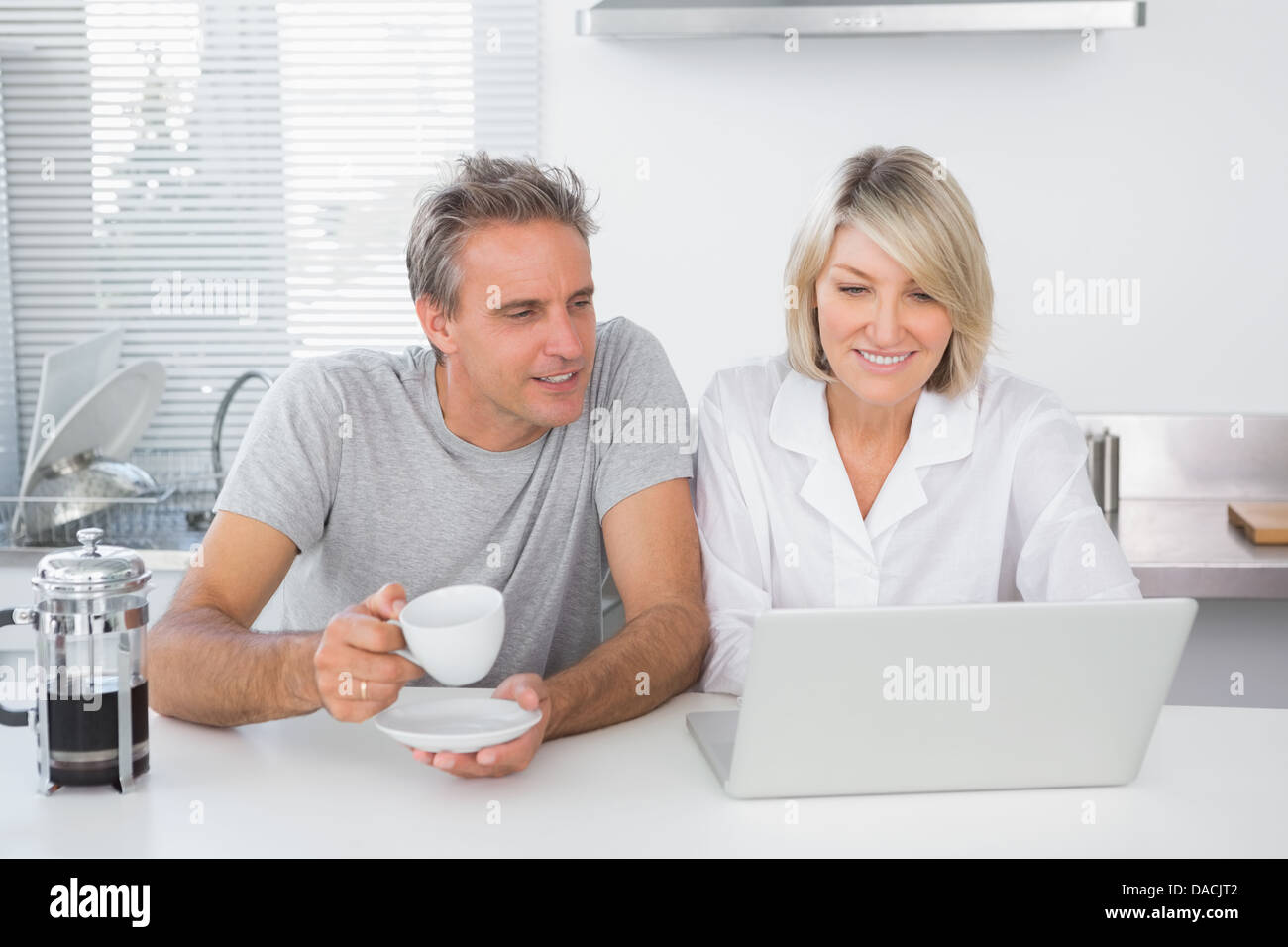Happy couple using laptop in the morning Stock Photo - Alamy
