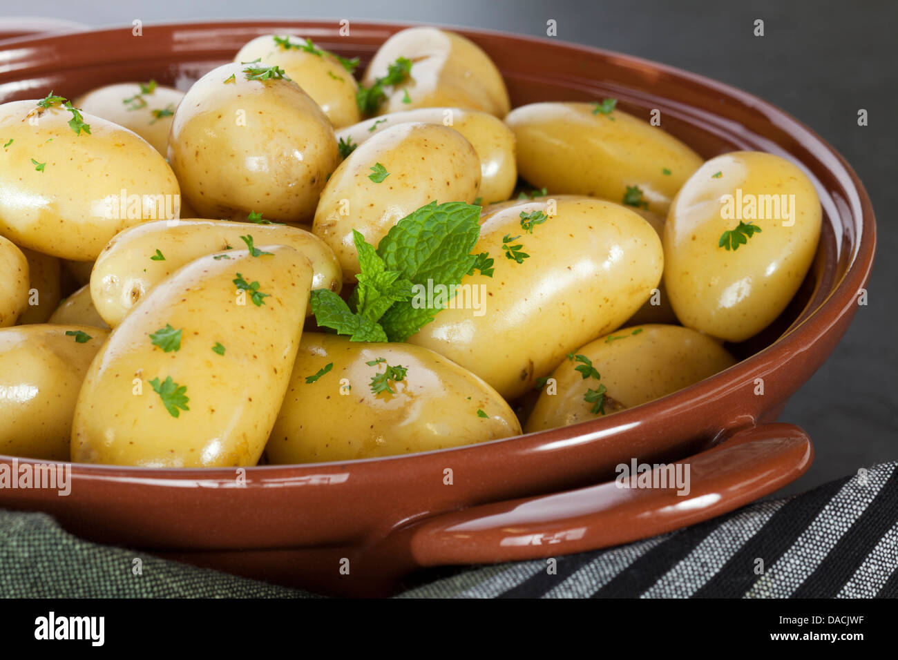 New Potatoes Steamed new potatoes in their skins with extra virgin olive oil, parsley and mint. Stock Photo