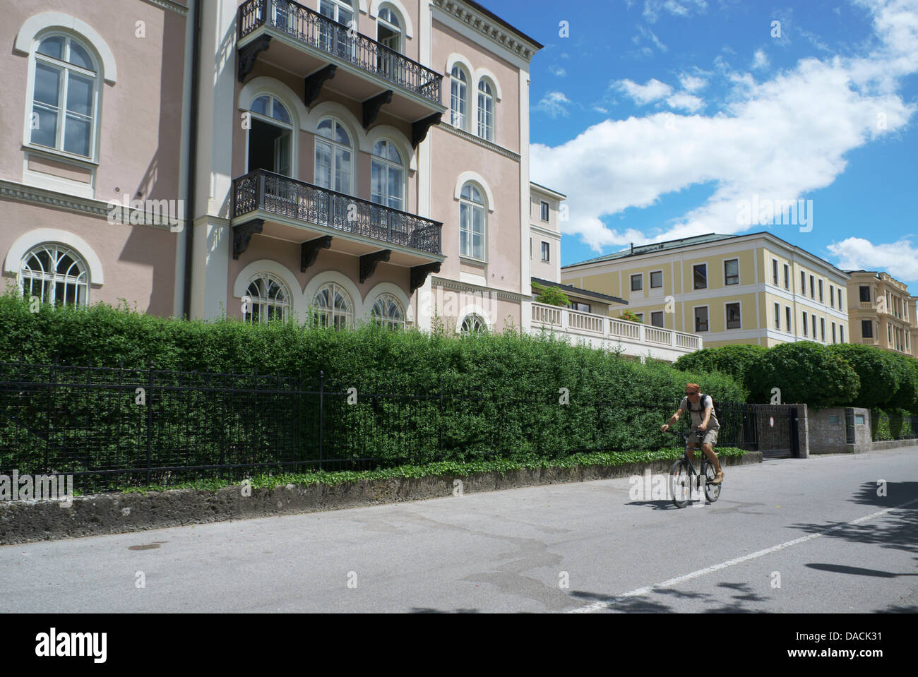 Salzburg, Austria Man riding a bicycle on Elisabethkai in the historic center of Salzburg, Austria. Stock Photo