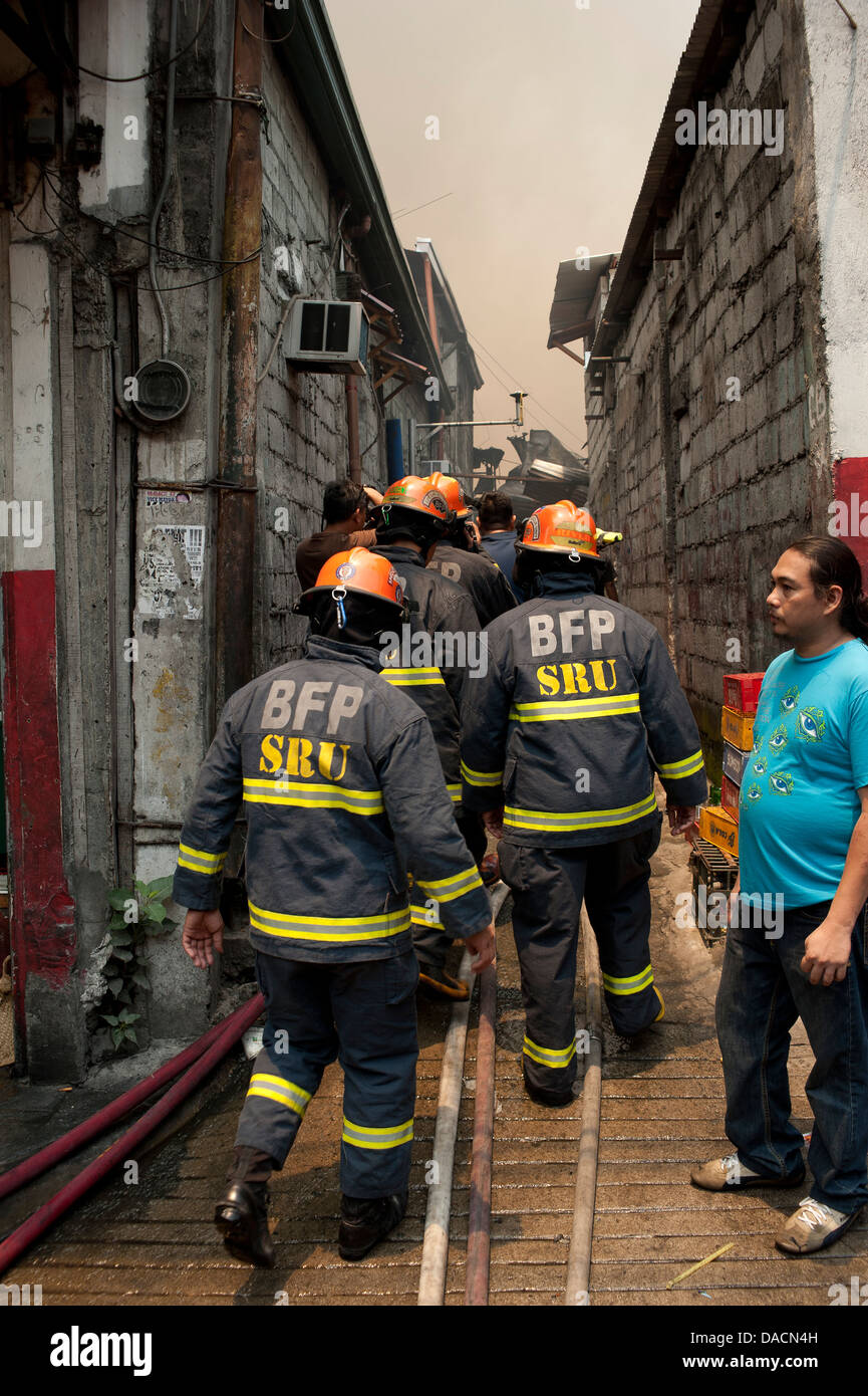 Firemen at a fire in a shanty town in Makati City, Metro Manila