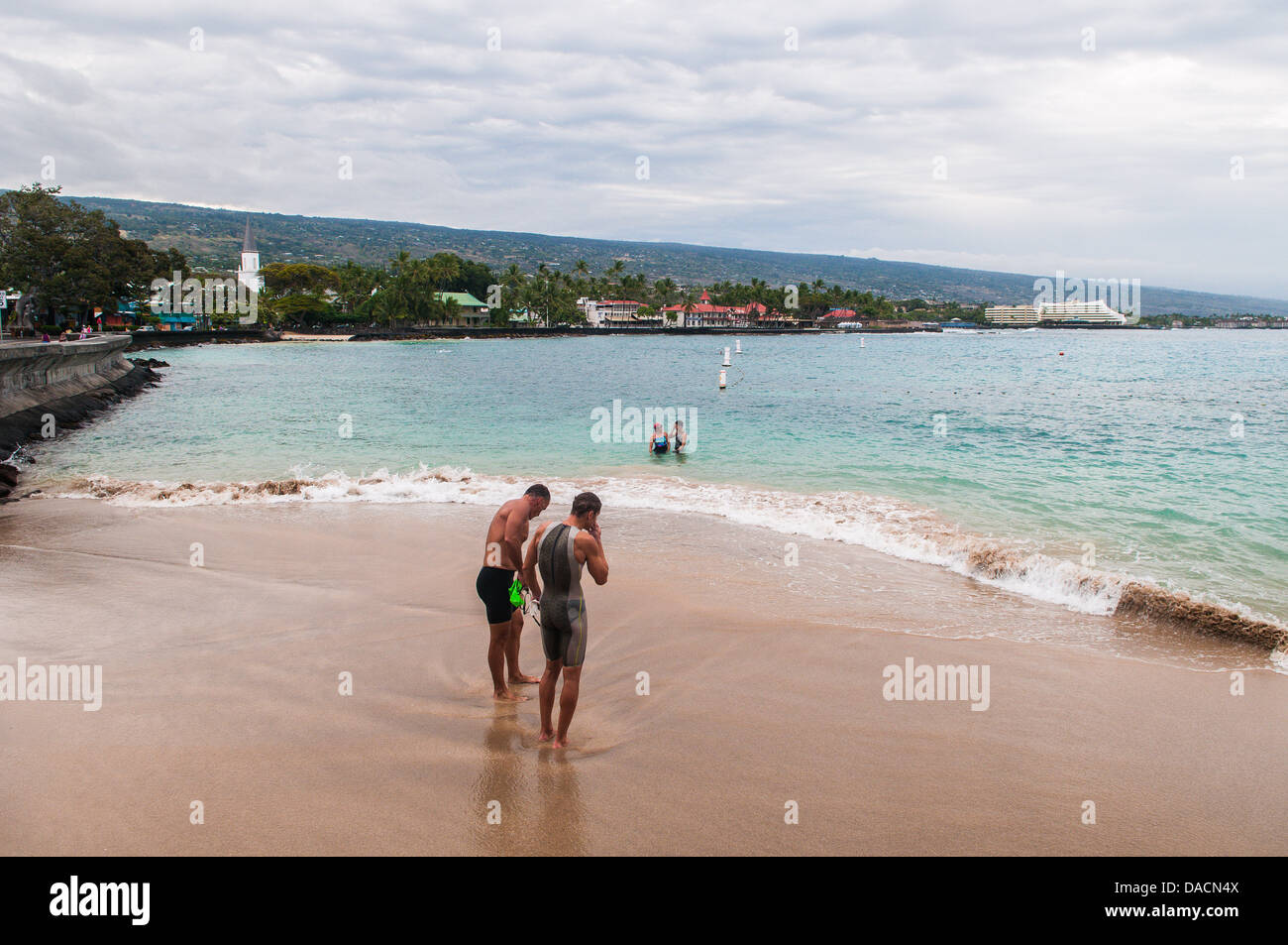 Swimmers on the beach at the official finish line of the Ironman triathlon course, Kailua-Kona, Hawaii (not taken on race day) Stock Photo