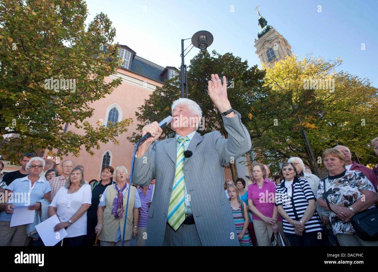 Choir leader Gotthilf Fischer (C) stands surrounded by a crowd singing folk songs on the market square in Eisenach, Germany, 30 September 2011. The event marks the prelude to the televised live event 'Die schoensten deutschen Volkslieder' (The most beautiful German folk songs) of German broadcasting station MDR, which nominates the most favourite song. Photo: Michael Reichel Stock Photo