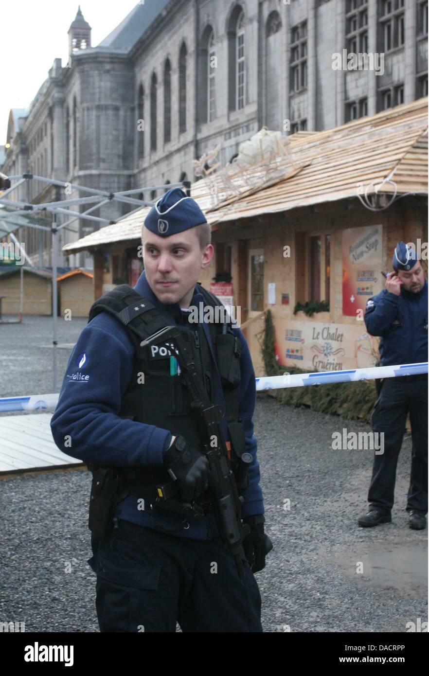 A police officer with a machine gun stands in front of the Christmas ...