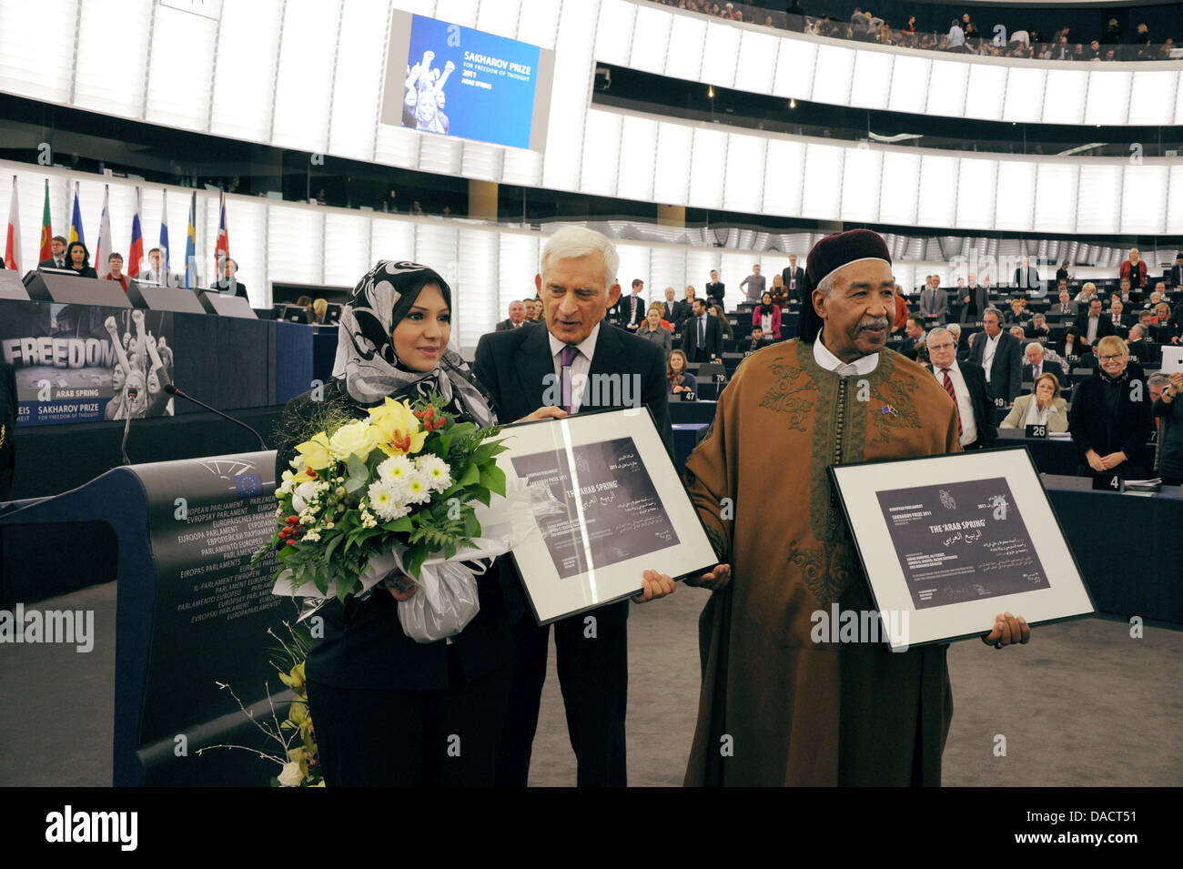 European Parliament President Jerzy Buzek (C) hands over the certificates to Asmaa Mahfouz (L) and Ahmed Al-Zubair Ahmed Al-Sanusi (R), two of the five Sakharov award winners at the European Parliament in Strasbourg, France, 14 December 2011.The Awards of the 2011 Sakharov Prize for freedom of thought was awarded to five Arab Spring activists for the historic changes in the Arab wo Stock Photo