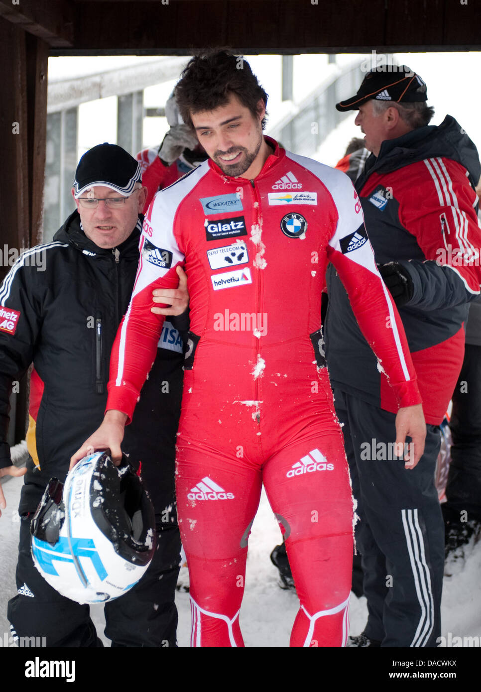 Swiss bob pilot Gregor Baumann is accompanied from the finish after a crash during the bob world cup in Winterberg, Germany, 18 December 2011. His crew remained unharmed and came in 11th place. Photo: Bernd Thissen Stock Photo