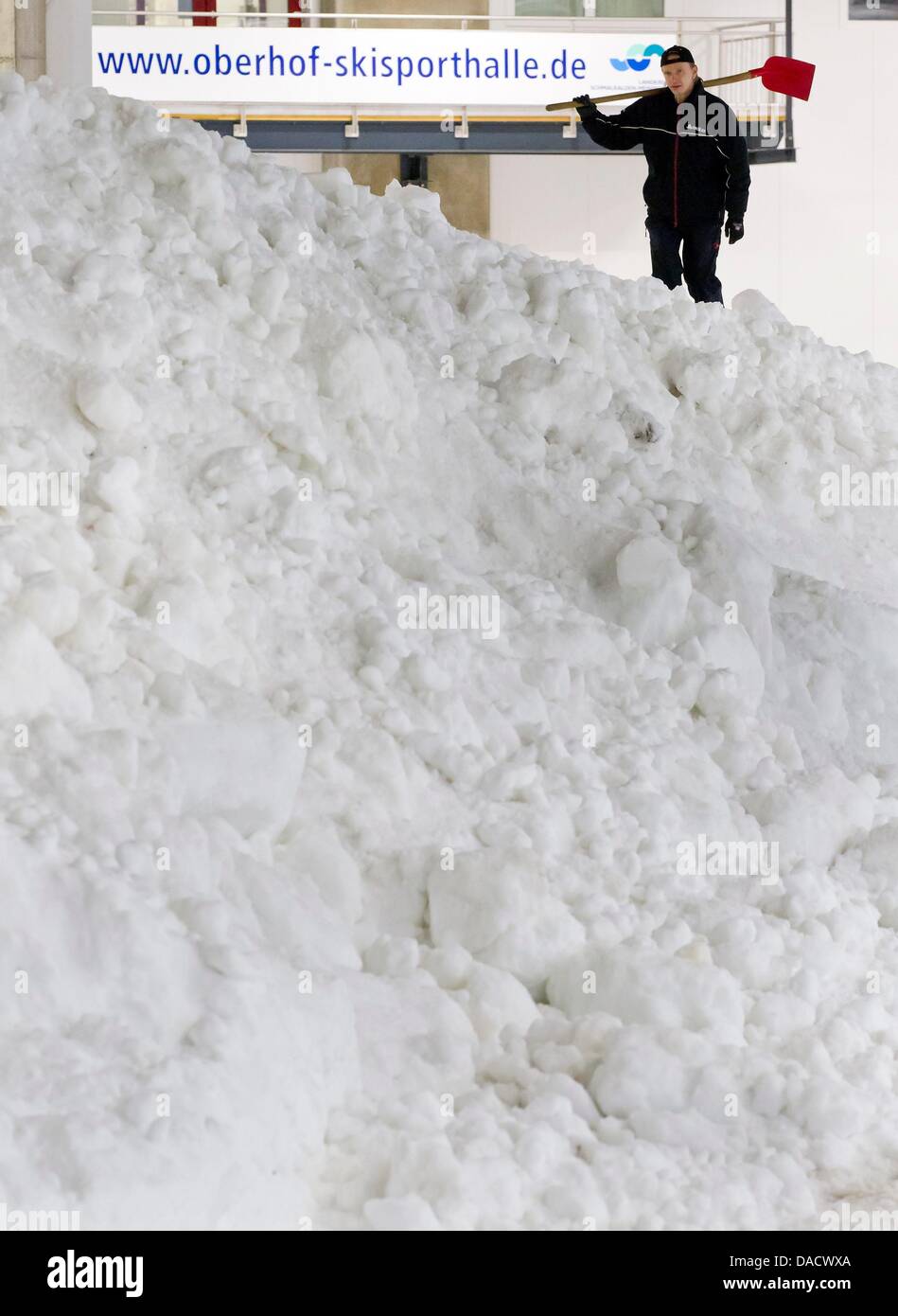 A technician works next to 1000 cubic meters of crushed ice at a ski sport venue in Oberhof, Germany, 19 December 2011. The ice is supposed to be used for the Tour de Ski on 29 and 30 December 2011 an dthe Biathlon World Cup on 4 - 8 January 2012 in Oberhof. Photo: MICHAEL REICHEL Stock Photo