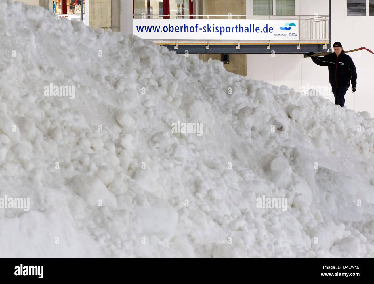A technician works next to 1000 cubic meters of crushed ice at a ski sport venue in Oberhof, Germany, 19 December 2011. The ice is supposed to be used for the Tour de Ski on 29 and 30 December 2011 an dthe Biathlon World Cup on 4 - 8 January 2012 in Oberhof. Photo: MICHAEL REICHEL Stock Photo