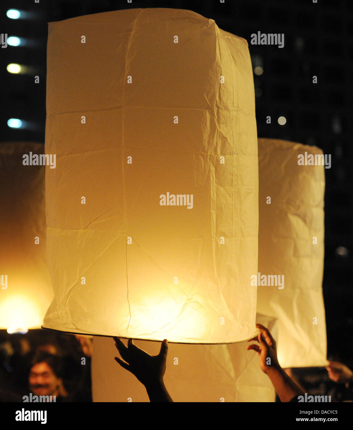 People light paper lanterns called Khom Loi at the Ping river during the festival of lights Loy Krathong in Chiang Mai, Thailand, 10 November 2011. The festival is celebrated in the whole country during full moon of the twelfth month of the year and originates from a Hindu tradition. Photo: Jens Kalaene Stock Photo