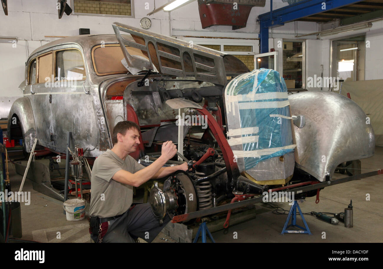 Automobile mechanic Peter Spillner works on the car body of a Mercedes