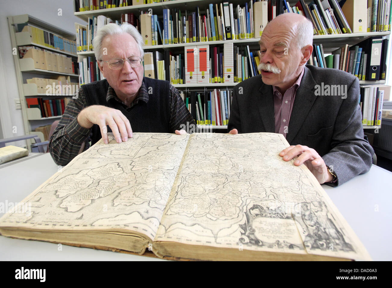 (FILE) An archive photo dated 09 December 2011 shows North Frisian historian Albert Panten (L) and director of the Nordfriisk Instituut, Prof. Thomas Steensen holding a book with a map with a the image of the reconstruction of the coastal area of North Frisia after the 'Grote Mandrenke' ('Great Drowning of Men') of 1362 in Bredstedt, Germany. The reconstruction was created by illus Stock Photo