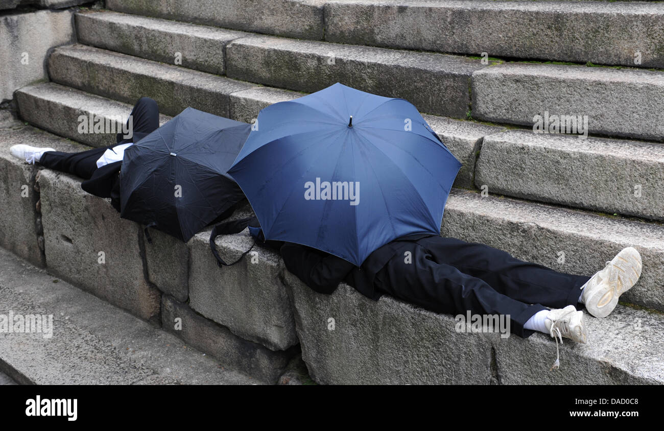 Two pupils take shelter from rain underneath an umbrella in Osaka, Japan, 18 November 2011. Photo: Angelika Warmuth Stock Photo
