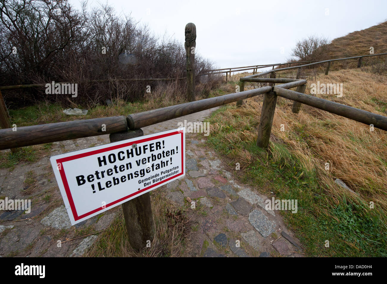 A sign which reads 'HOCHUFER! Betreten verboten! !Lebensgefahr!', Coastal cliffs! Keep off the ground! !Danger to life!, stands on the access pathway to the steep cliff line at Cape Arkona on the island of Ruegen, Putgarten, Germany, 28 December 2011. On Monday afternoon, 26 December 2011, several thousand cubic metres of clay and chalkstone crashed into the sea taking by surprise  Stock Photo