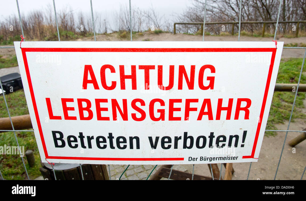 A sign which reads 'Achtung Lebensgefahr, Betreten verboten!', Attention, danger to life, keep off the ground!' on the access pathway to the steep cliff line at Cape Arkona on the island of Ruegen, Putgarten, Germany, 28 December 2011. On Monday afternoon, 26 December 2011, several thousand cubic metres of clay and chalkstone crashed into the sea taking by surprise a mother and her Stock Photo