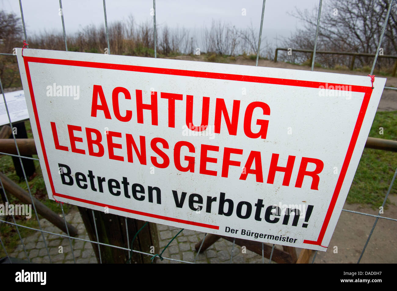 A sign which reads 'Achtung Lebensgefahr, Betreten verboten!', Attention, danger to life, keep off the ground!' on the access pathway to the steep cliff line at Cape Arkona on the island of Ruegen, Putgarten, Germany, 28 December 2011. On Monday afternoon, 26 December 2011, several thousand cubic metres of clay and chalkstone crashed into the sea taking by surprise a mother and her Stock Photo
