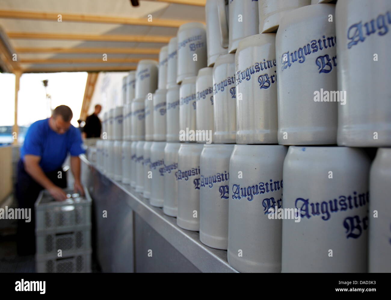 A man packs beer mugs of the Augustiner brewery after the end of Oktoberfest in Munich, Germany, 04 October 2011. The Oktoberfest has witnessed a veritable onslaught of visitors this year. Perfect weather conditions and the nostalgic charm of the 'Oide Wiesn' have drawn more visitors than last year. Despite the increased number of visitors there were fewer police deployments and fe Stock Photo